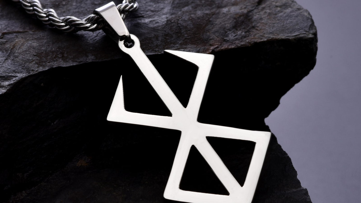 Berserk Brand of Sacrifice titanium pendant photographed on dark slate
